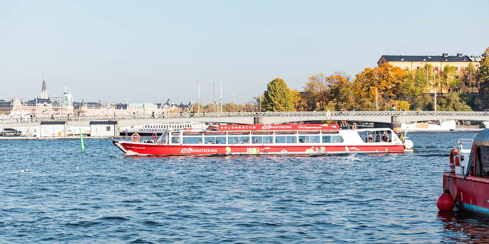 HOHO boat in Stockholm on the water with a bridge and buildings on the background