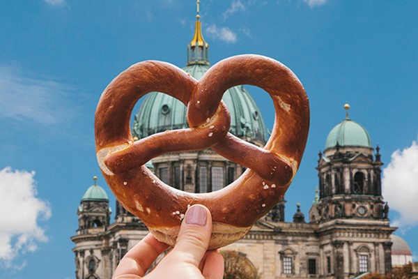 Girl Holding A Brezel In Front Of The Reichstag + Blue Clear Sky